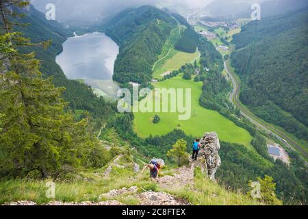 Wanderer genießen bei Regenwetter im Sommer einen fantastischen Panoramablick über die alpine Landschaft mit Leopoldsteiner See und Eisenerz. Stockfoto