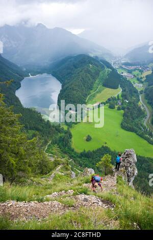 Wanderer genießen einen fantastischen Panoramablick über die alpine Landschaft mit Leopoldsteiner See, Eisenerz und berühmten Erzberg bei Regenwetter im Sommer. Stockfoto
