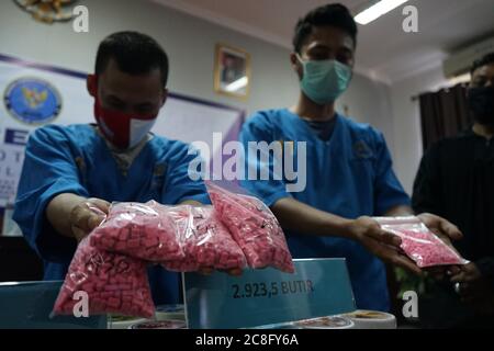 Makassar, Indonesien. Juli 2020. Der Drogenhändler hält Tausende Ecstasy-Pillen, die von der Nationalen Betäubungsmittelbehörde der Provinz Süd-Sulawesi zusammen mit Zollbeamten erfolgreich vereitelt wurden. Diese Art von Ecstasy-Betäubungsmitteln stammt aus dem Ausland von Sulawesi und wird über Paketzustellungsdienste verschickt, wurde jedoch vereitelt, bevor sie in eine Reihe von Gebieten in Süd-Sulawesi geliefert werden. (Foto von Herwin Bahar/Pacific Press) Quelle: Pacific Press Agency/Alamy Live News Stockfoto