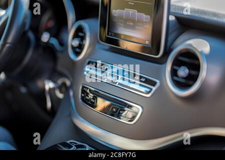 05.07.19 - Österreich: Nahaufnahme des Innenraums der braunen, offenporigen Eschenholzverkleidung an der Mittelkonsole, Radio, Klimaanlage, LCD-Bildschirm Luxuswagen Stockfoto