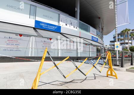 Costa Adeje, Teneriffa, Kanarische Inseln, Spanien. 24. Juli 2020. Banner, die die Wiedereröffnung ankündigen und sagen, dass wir Touristen lieben, in einem Schaufenster, während die Plaza del Duque sich darauf vorbereitet, ihre Türen für Touristen wieder zu öffnen. Das gehobene Einkaufszentrum ist seit dem 14. März geschlossen, als die Covid 19-Sperre begann. Stockfoto