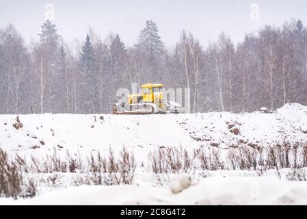 Schneeräumung. Traktor ebnet den Weg nach starkem Schneefall. Stockfoto