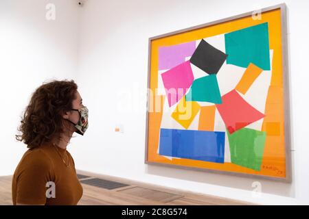 London, Großbritannien. Juli 2020. Ein Mitarbeiter mit Gesichtsmaske sieht ein Gemälde während einer Pressevorschau für die Wiedereröffnung des Tate Modern Art Museum in London, Großbritannien, am 24. Juli 2020. Die Kunstmuseen Tate Modern, Tate Britain, Tate Liverpool und Tate St Ives werden nach ihrer Schließung aufgrund der COVID-19-Pandemie ab Juli 27 wieder für die Öffentlichkeit zugänglich sein. Quelle: Ray Tang/Xinhua/Alamy Live News Stockfoto