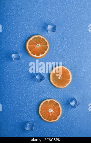 Scheiben von frischem Orange auf blauem Hintergrund mit Eis. Stockfoto