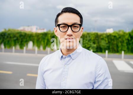 Porträt eines Mannes mit hellblauem Hemd und Brille, der die Kamera anschaut. Stockfoto