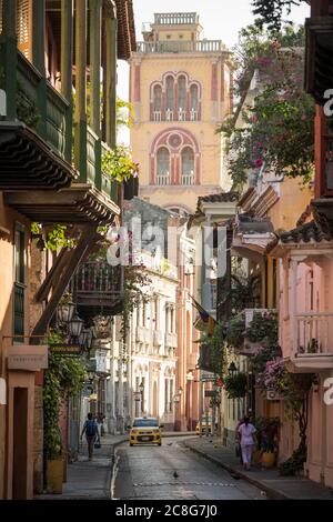 Blick auf die enge Straße in der Altstadt, elegante historische Häuser mit Balkon und hohen Kirchturm Stockfoto