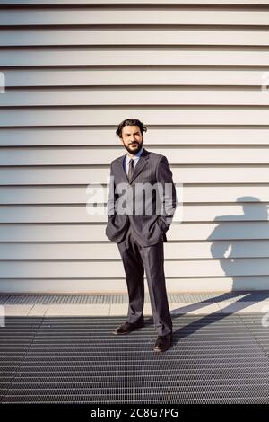 Porträt eines bärtigen Geschäftsmannes in dunklem Anzug, der die Kamera anschaut. Stockfoto