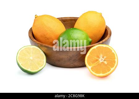 Frische verschiedene Zitrusfrüchte isoliert auf weißem Hintergrund. Frische Zitronen Meyer und Limetten in der Holzschale. Stockfoto