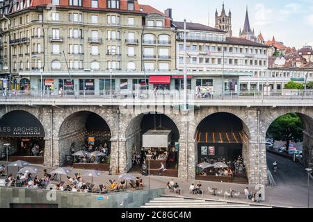 Lausanne Schweiz , 25 Juni 2020 : Les Arches Bar mit Terrasse voller Menschen unter den Grand-Pont-Brückenbögen und Blick auf die Stadt während 2020 covid cr Stockfoto