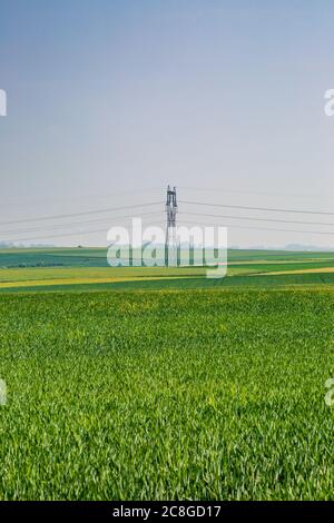 Ein Strommast, der durch eine grüne französische ländliche Landschaft läuft Stockfoto