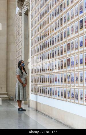 London, Großbritannien. Juli 2020. Ein Assistent betrachtet Bilder aus der Steve McQueen Ausstellung "Year 3, A Portrait of London". Die Tate Britain und andere Tate Galleries im Land werden ab Montag, 27. Juli, wieder für Besucher geöffnet, mit sozialen Distanzierungsmaßnahmen. Kredit: Imageplotter/Alamy Live Nachrichten Stockfoto