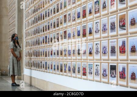 London, Großbritannien. Juli 2020. Ein Assistent betrachtet Bilder aus der Steve McQueen Ausstellung "Year 3, A Portrait of London". Die Tate Britain und andere Tate Galleries im Land werden ab Montag, 27. Juli, wieder für Besucher geöffnet, mit sozialen Distanzierungsmaßnahmen. Kredit: Imageplotter/Alamy Live Nachrichten Stockfoto