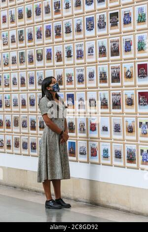 London, Großbritannien. Juli 2020. Ein Assistent betrachtet Bilder aus der Steve McQueen Ausstellung "Year 3, A Portrait of London". Die Tate Britain und andere Tate Galleries im Land werden ab Montag, 27. Juli, wieder für Besucher geöffnet, mit sozialen Distanzierungsmaßnahmen. Kredit: Imageplotter/Alamy Live Nachrichten Stockfoto