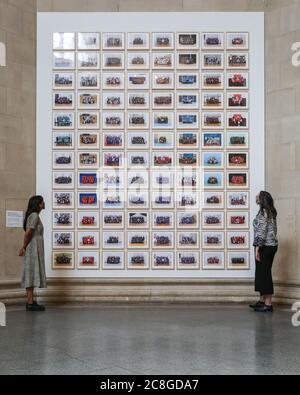 London, Großbritannien. Juli 2020. Zwei Assistenten betrachten Bilder aus der Steve McQueen Ausstellung "Year 3, A Portrait of London". Die Tate Britain und andere Tate Galleries im Land werden ab Montag, 27. Juli, wieder für Besucher geöffnet, mit sozialen Distanzierungsmaßnahmen. Kredit: Imageplotter/Alamy Live Nachrichten Stockfoto