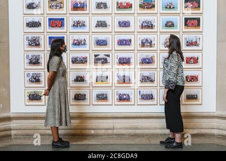 London, Großbritannien. Juli 2020. Zwei Assistenten betrachten Bilder aus der Steve McQueen Ausstellung "Year 3, A Portrait of London". Die Tate Britain und andere Tate Galleries im Land werden ab Montag, 27. Juli, wieder für Besucher geöffnet, mit sozialen Distanzierungsmaßnahmen. Kredit: Imageplotter/Alamy Live Nachrichten Stockfoto