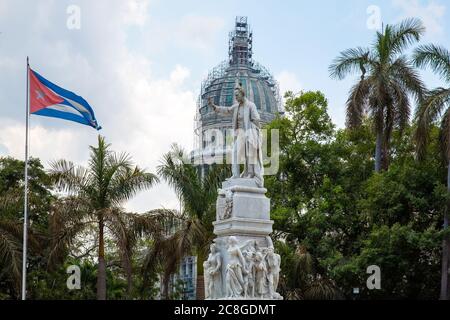 Havanna / Kuba - 04.15.2015: Die weiße Marmorstatue des berühmten Dichters Jose Marti mit Blick auf die Nationalflagge Kubas, Vögel auf der Hand und dem Kopf. Hinter Stockfoto