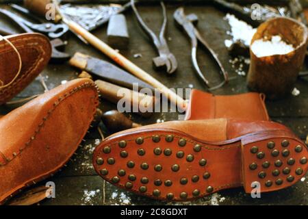 Weicher Fokus der Sohle eines braunen Lederstiefelsohles mit Hobnails In einem Schuhmacherladen Stockfoto