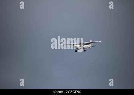 Kleines Flugzeug gegen einen blauen Himmel, das an Land kommt Stockfoto