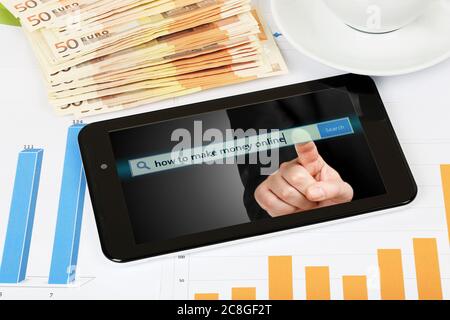 Tablet-Computer mit Grafiken und Banknoten, Geld verdienen Online-Konzept Stockfoto