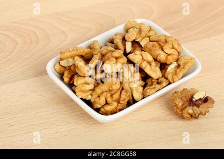 Schale mit geschälten Walnüssen auf Holztisch Stockfoto