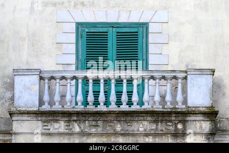 Alte grüne Fensterläden, die ein Fenster auf einem Steinbalkon eines Hauses in Amalfi, Italien, bedecken Stockfoto