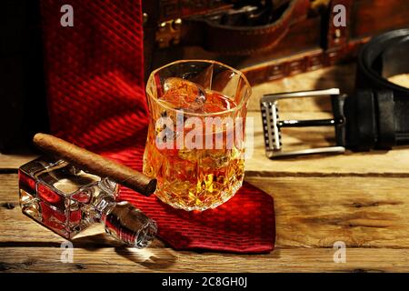 Elegantes Glas Whiskey auf den Felsen und Zigarre mit Bekleidungszubehör Stockfoto