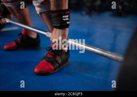 Anonymer Sportler, der sich beim funktionellen Training im Fitnessstudio auf den Deadlift vorbereitet Stockfoto