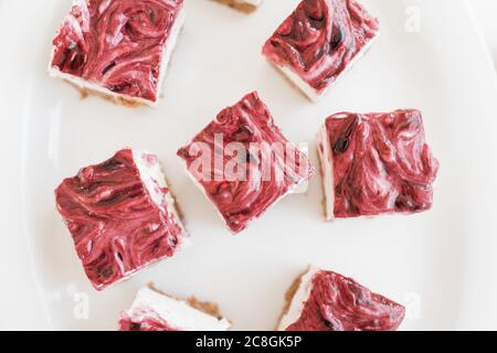 Nahaufnahme von Erdbeerkäsekuchen in Quadrate geschnitten Stockfoto