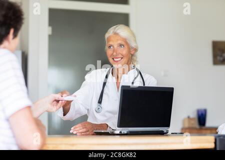 Ältere Ärztin weiblich arbeiten in einer Praxis mit Patienten Stockfoto