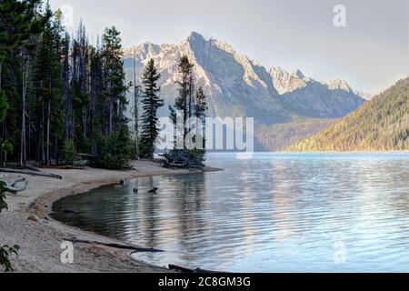 Ein Blick auf den Berg Heyburn am Tag spiegelt sich im kristallklaren Wasser des Redfish Lake im Zentrum von Idaho wider. Stockfoto