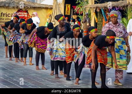 Gruppe von afrikanischen Mädchen tragen traditionelle Kostüme und Tanz in afrikanischen Festival in Katara Kulturdorf, Doha Katar Stockfoto