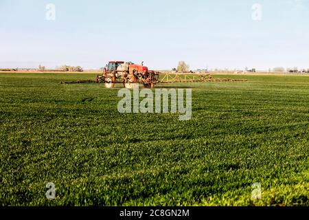 American Falls, Idaho, USA 2. Mai 2012 EIN langarmes Düngemittel-Sprühgerät, das Düngemittel auf landwirtschaftlichen Feldern sprüht. Stockfoto