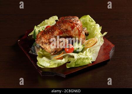 Ganze gegrillte Hähnchen mit Gemüse mit Sauce auf einem Holztisch Stockfoto
