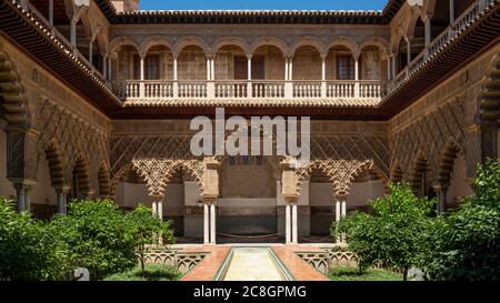 Patio de las Doncellas oder der Innenhof der Mädchen mit einem üppigen Garten mit kleinen Orangenbäumen und einem dünnen Pool, der den Raum teilt, Royal Alcazar Stockfoto