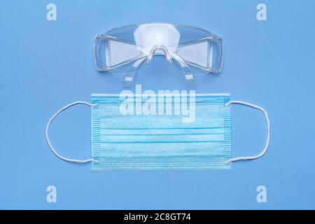 Maske und Schutzbrille für persönlichen Schutz auf blauem Untergrund Stockfoto