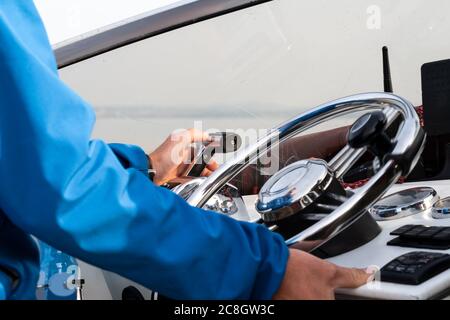 Die Hand des Mannes am Lenkrad eines Motorbootes aus nächster Nähe Stockfoto