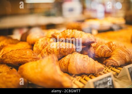 Croissants in der Vitrine der Bäckerei. Nahaufnahme von schönen appetitlichen goldenen Croissants im Café am Schaufenster. Auswahl an leckeren und buttrigen Stockfoto