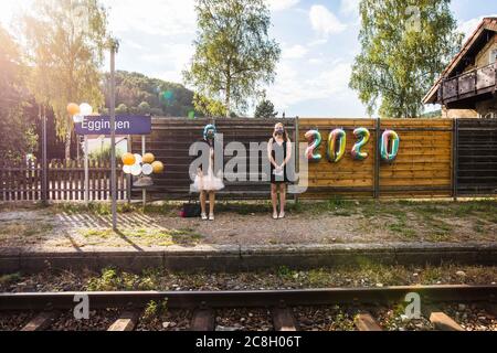 Egtingen, Deutschland. Juli 2020. Zwei Schüler der Klasse 10b der Realschule Stühlingen warten auf die Ankunft des Sonderzuges, der sie von Eggingen nach Stühlingen bringt, während ihre Urkunden ausgestellt werden. Die drei Abschlussklassen der Realschule Stühlingen erhalten ihre Berichte auf der Fahrt von Egtingen nach Stühlingen im Zug - da aufgrund der Corona-Pandemie keine normale Abschlussfeier stattfinden kann. Quelle: Philipp von Ditfurth/dpa/Alamy Live News Stockfoto