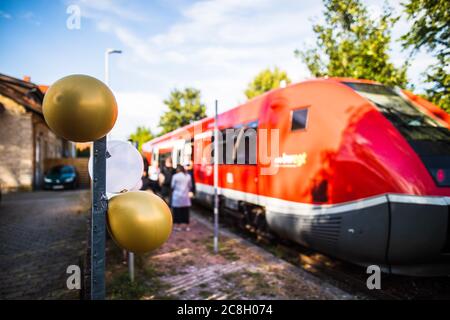 Egtingen, Deutschland. Juli 2020. Drei Ballons hängen an einem Pol am Bahnhof in Eggingen, im Hintergrund ist ein Zug zu sehen, in dem die Schüler der Klasse 10b der Realschule Stühlingen während der folgenden Fahrt ihre Diplome erhalten. Die drei Abschlussklassen der Realschule Stühlingen erhalten ihre Urkunden während der Fahrt von Egtingen nach Stühlingen im Zug - da aufgrund der Corona-Pandemie keine normale Abschlussfeier stattfinden kann. Quelle: Philipp von Ditfurth/dpa/Alamy Live News Stockfoto