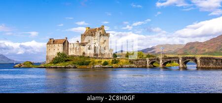 Dornie, SCHOTTLAND: Sommertage mit blauem Himmel über dem schönen schottischen Schloss Eilean Donan inmitten eines Sees. Stockfoto