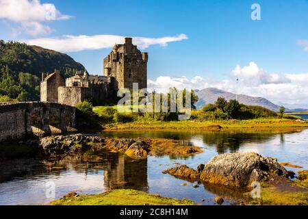 Dornie, SCHOTTLAND: Sommertage mit blauem Himmel über dem schönen schottischen Schloss Eilean Donan inmitten eines Sees. Stockfoto