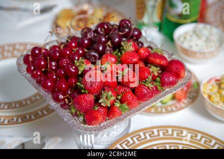 Frische Sommerfrüchte: Kirschen, Bio Erdbeeren Kristallschale . Erdbeeren und Kirschen in einer Kristallschale. Stockfoto