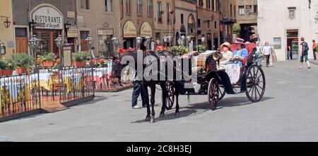 Italienische Pferdekutsche geöffnet zwei Frauen Passagiere Ankunft an Bürgersteig Bars & Ristorante auf der sonnigen Piazza della Signoria Florenz Toskana Italien EU Stockfoto