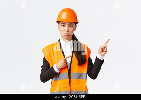 Bau-, Bau- und Industriekonzept. Verärgert und enttäuscht weibliche asiatische Managerin, Ingenieur in Sicherheit Helm Pouting, beschwert sich etwas Stockfoto