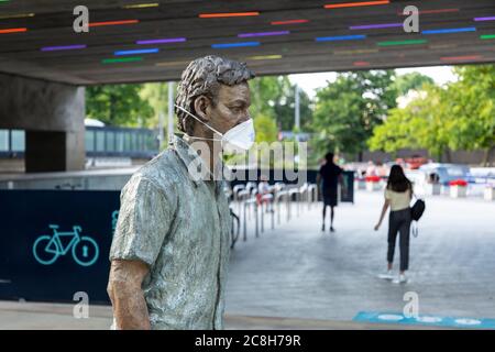 Eine Gesichtsmaske, die an einer öffentlichen Skulptur während der COVID-19 Pandemie angebracht ist, Paddington, London, 22. Juli 2020 Stockfoto