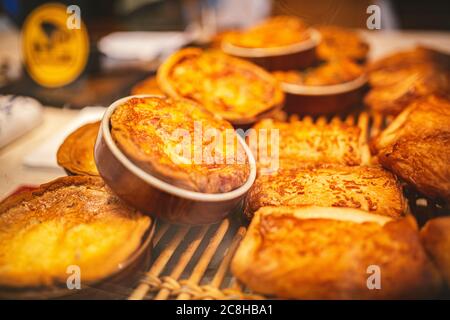 Verschiedene Backwaren, süße Kuchen, mit Käse und Brot. Nahaufnahme eines Brötchen mit Käse auf der Theke im Laden. Schaukasten mit Gebäck Stockfoto