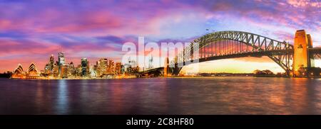 Heller, farbenfroher Sonnenuntergang über den Wahrzeichen von Sydney, CBD, mit Hafenbrücke. Stockfoto