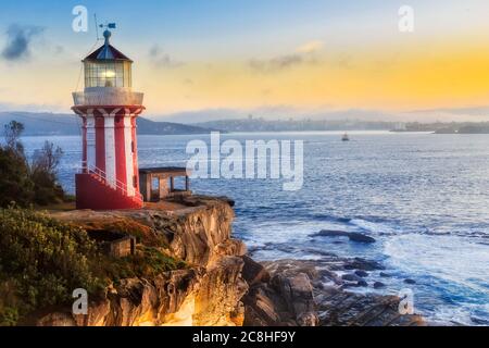 Hornby Leuchtturm und Fähre von Sydney nach Manly bei Sonnenaufgang am Rande des Sandsteinfelsen in der Nähe Sydnay Hafeneingang. Stockfoto