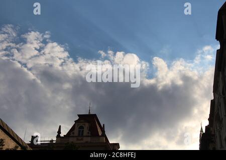 Wolken - große kumulative Wolken von der Straße Kostelni in Prag, Tschechische Republik gesehen; man kann Sonnenstrahlen durch die Wolken kommen sehen Stockfoto