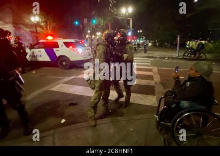 Portland, Oregon, USA. Juli 2020. Ein Mann im Rollstuhl beschimpft einen Bundesagenten, während sie diskutieren, wie man Demonstranten festnimmt. Quelle: Amy Katz/ZUMA Wire/Alamy Live News Stockfoto